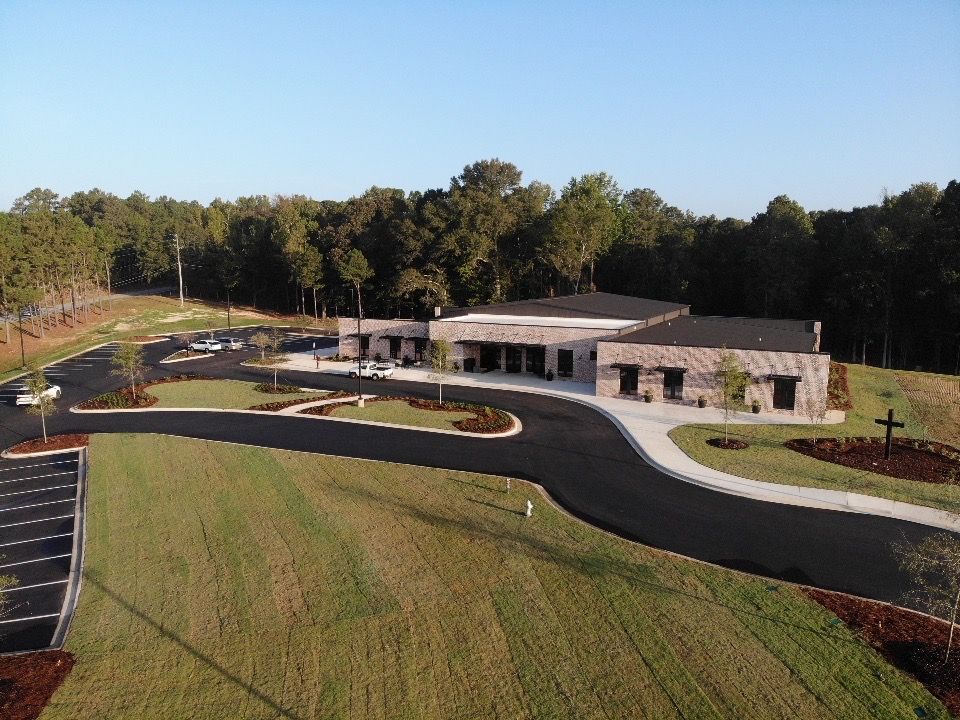 An aerial view of a building with a cross in front of it