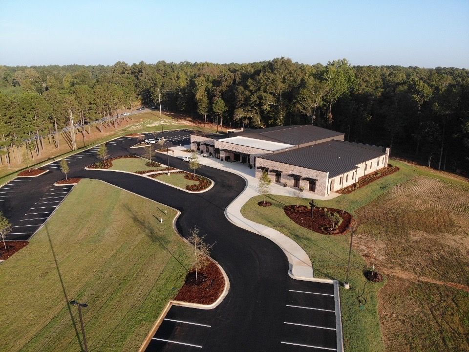 An aerial view of a building with a parking lot in front of it