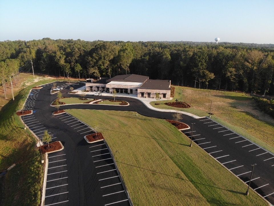 An aerial view of a parking lot with a building in the background