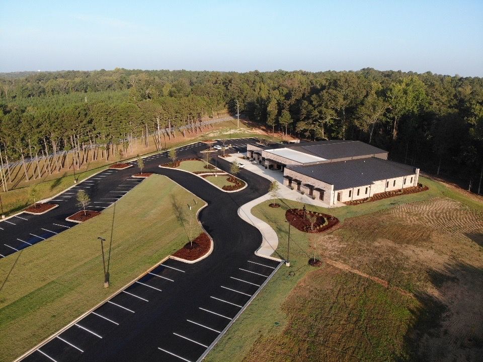 An aerial view of a building with a parking lot in front of it
