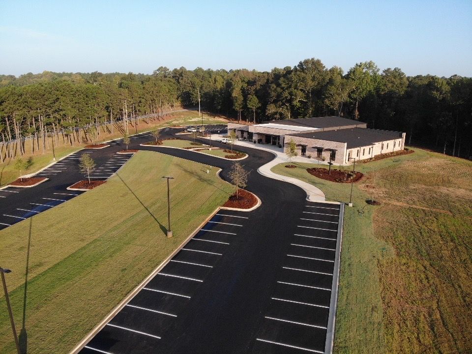 An aerial view of a parking lot with a building in the background