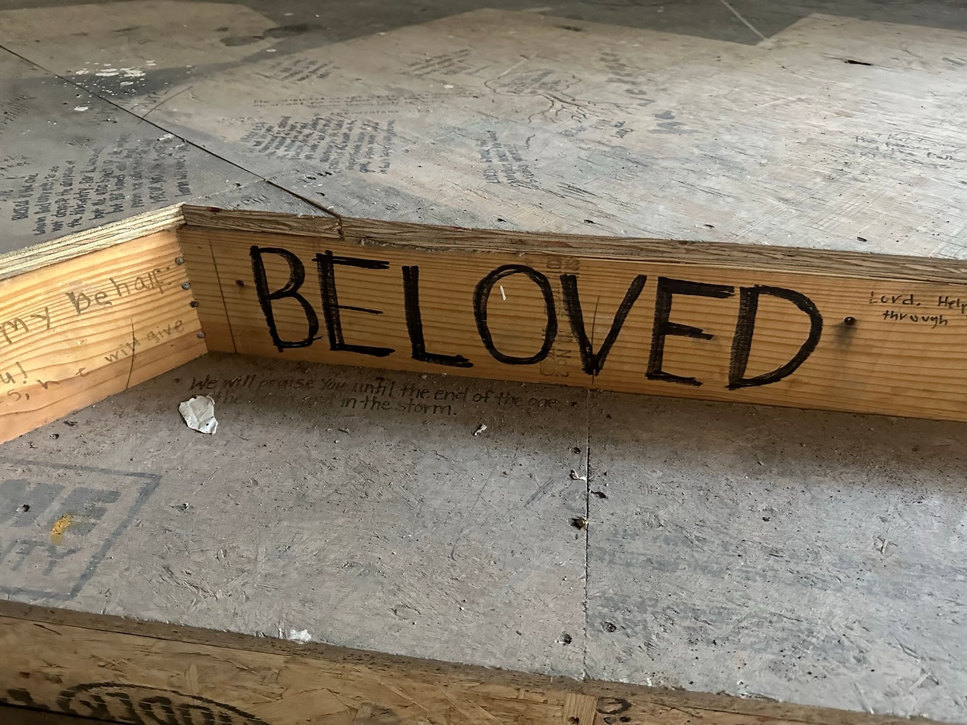 A piece of wood with the word beloved written on it