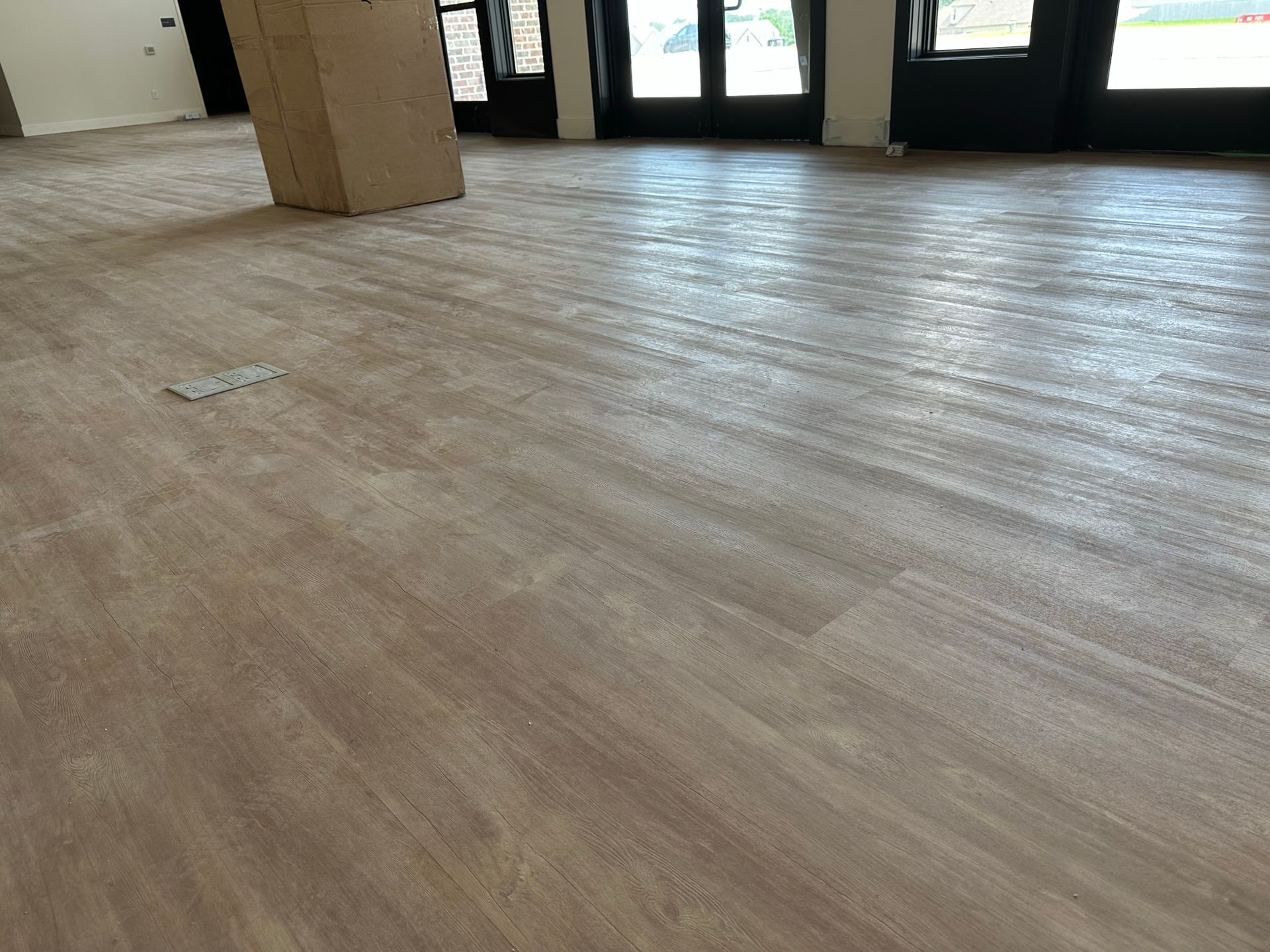 A large room with a wooden floor and a pillar.