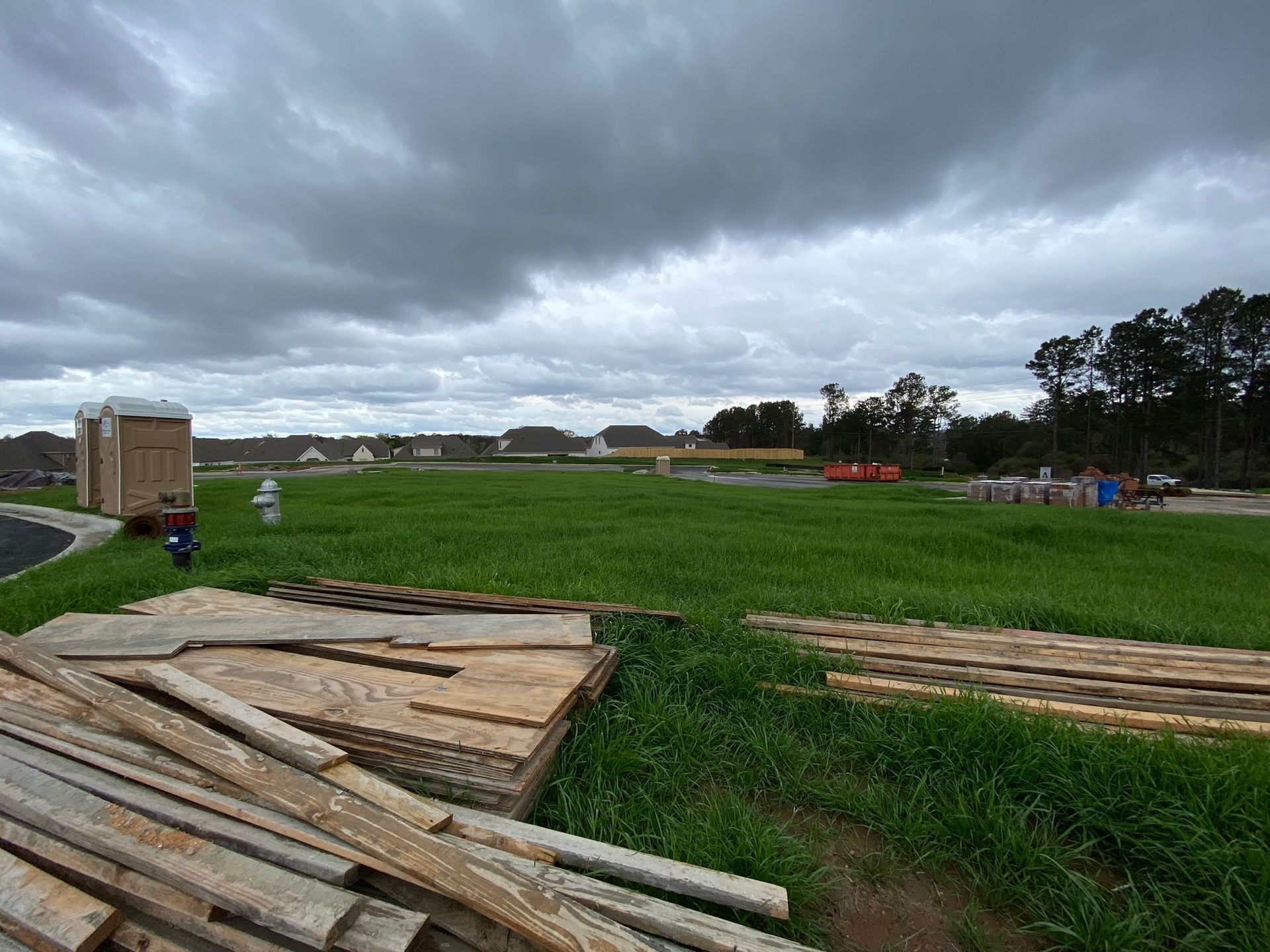 A stack of wood is sitting in the middle of a grassy field.