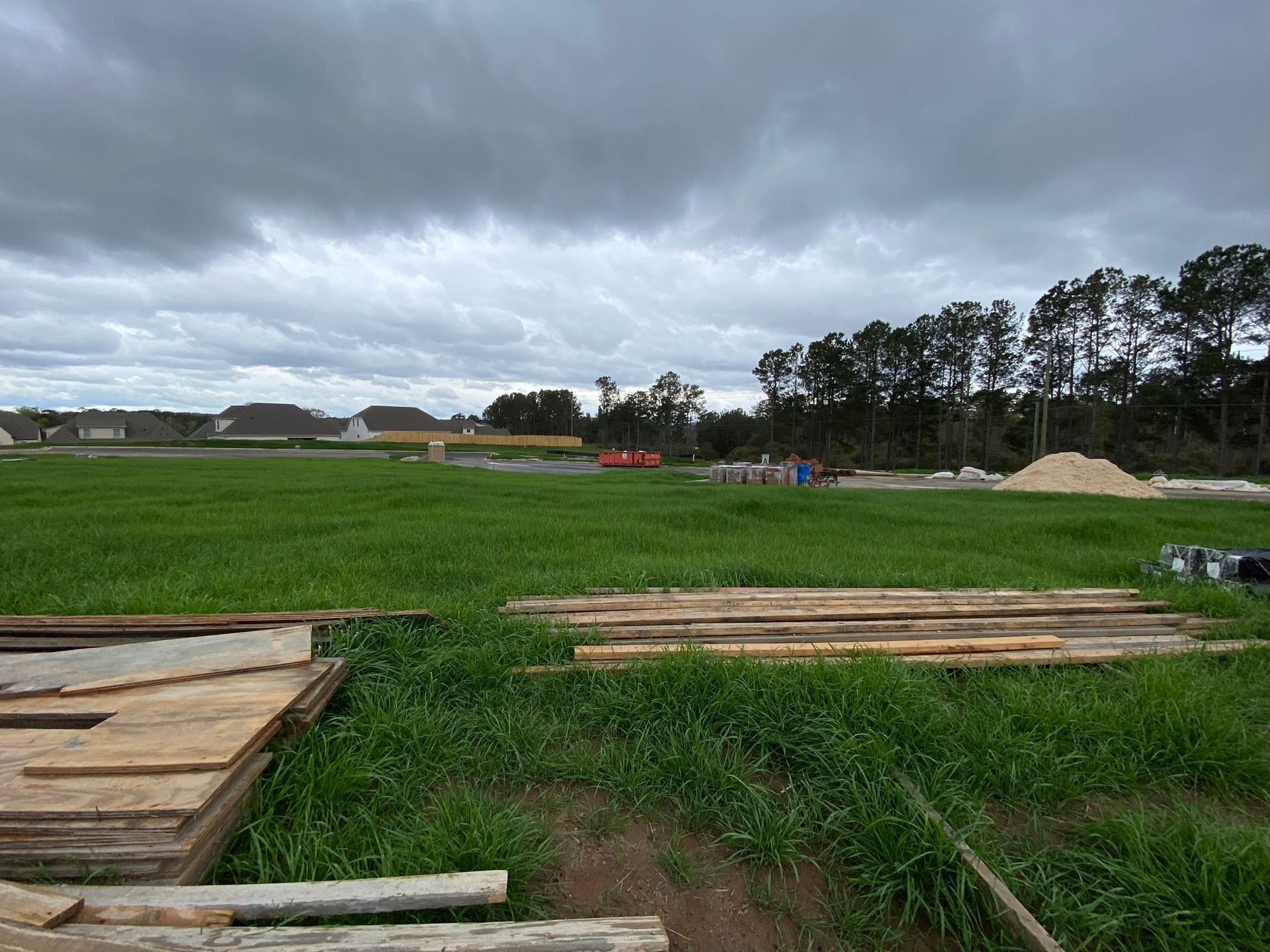 A large grassy field with a cloudy sky in the background