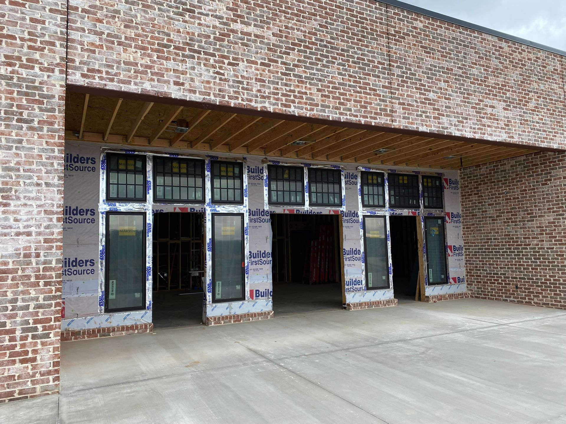 A large brick building with a lot of windows is under construction.