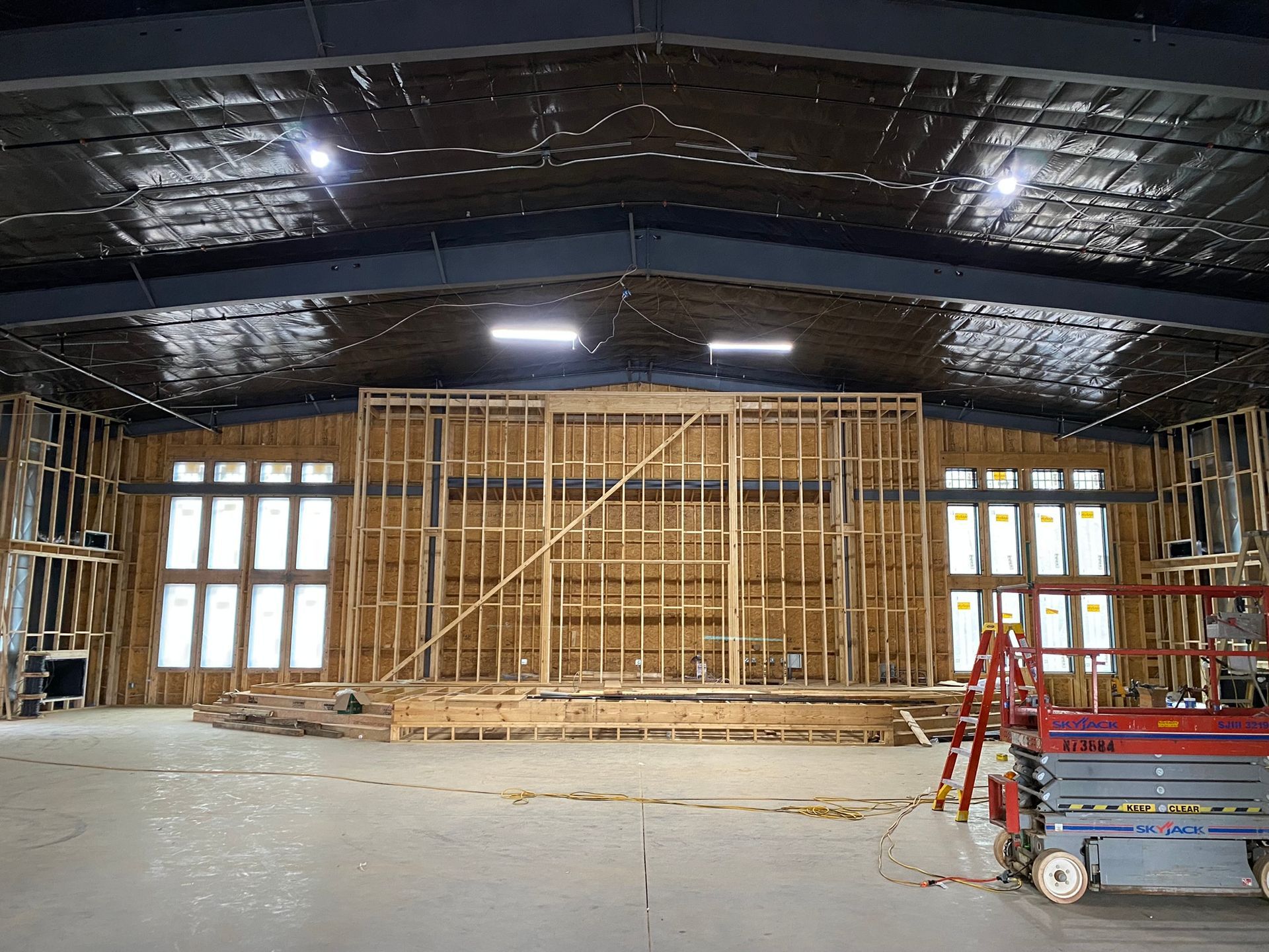 A large building under construction with a lot of windows and a ladder.