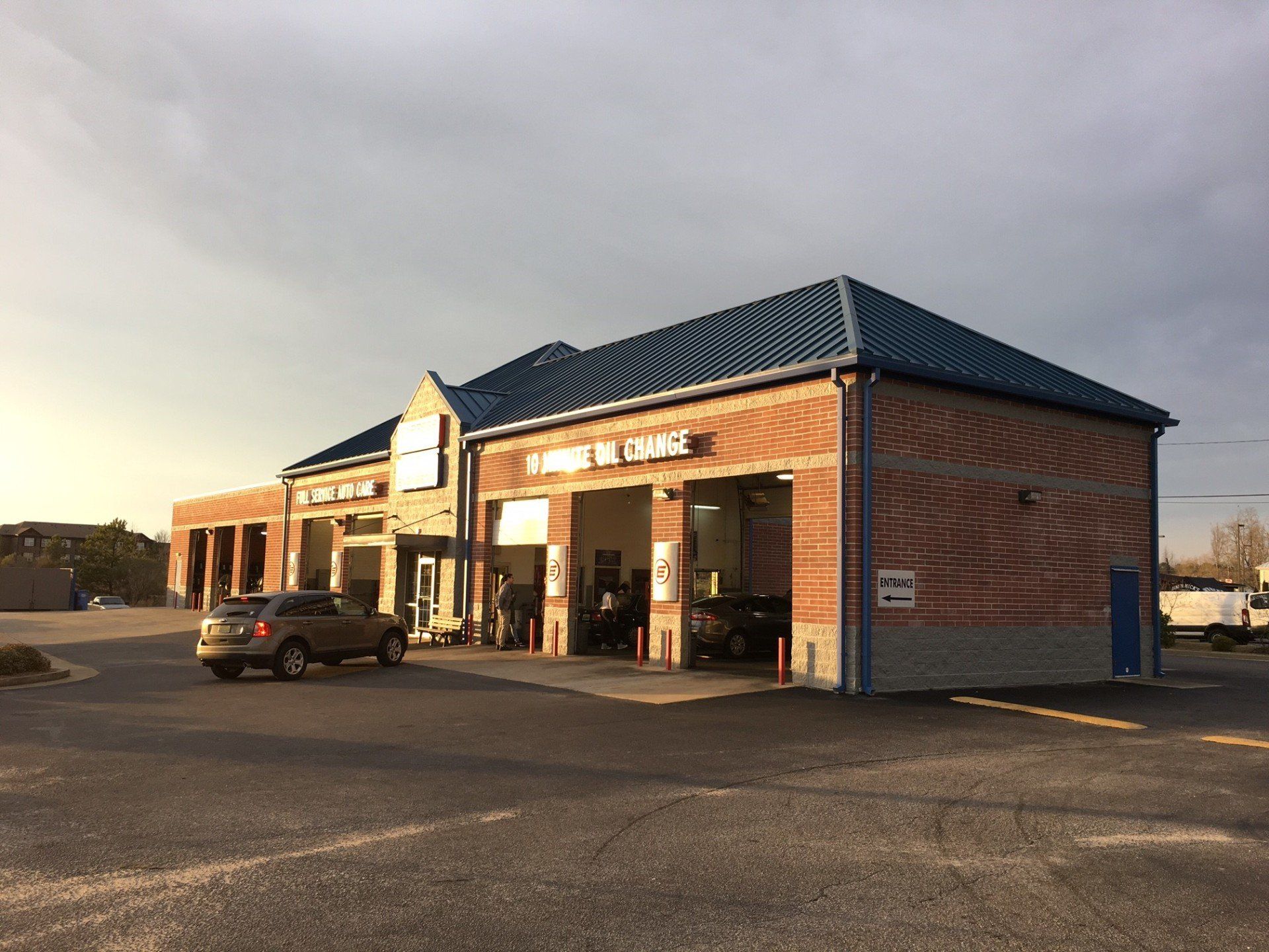 A car is parked in front of a tire shop.