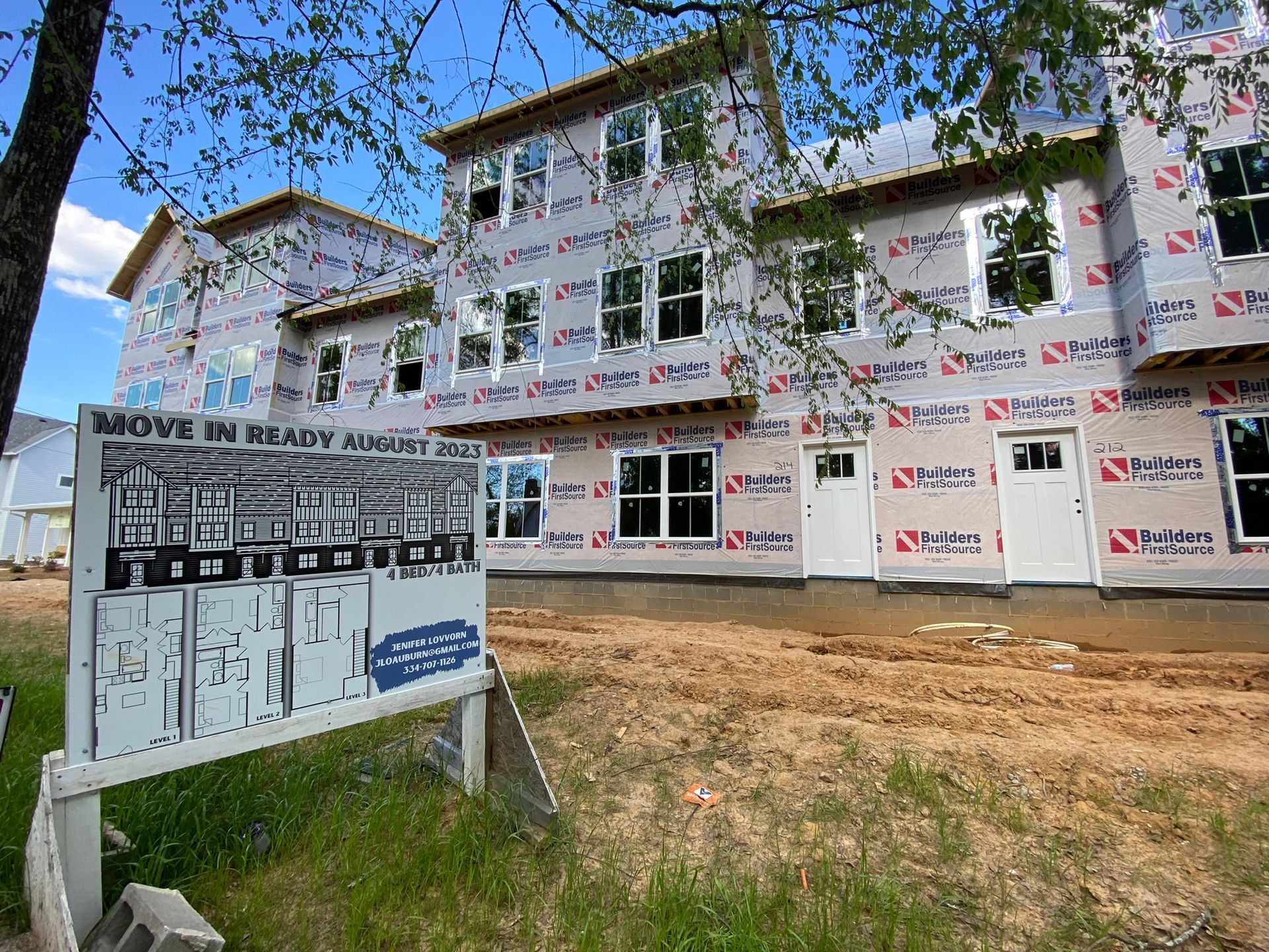 A large house under construction with a sign in front of it.