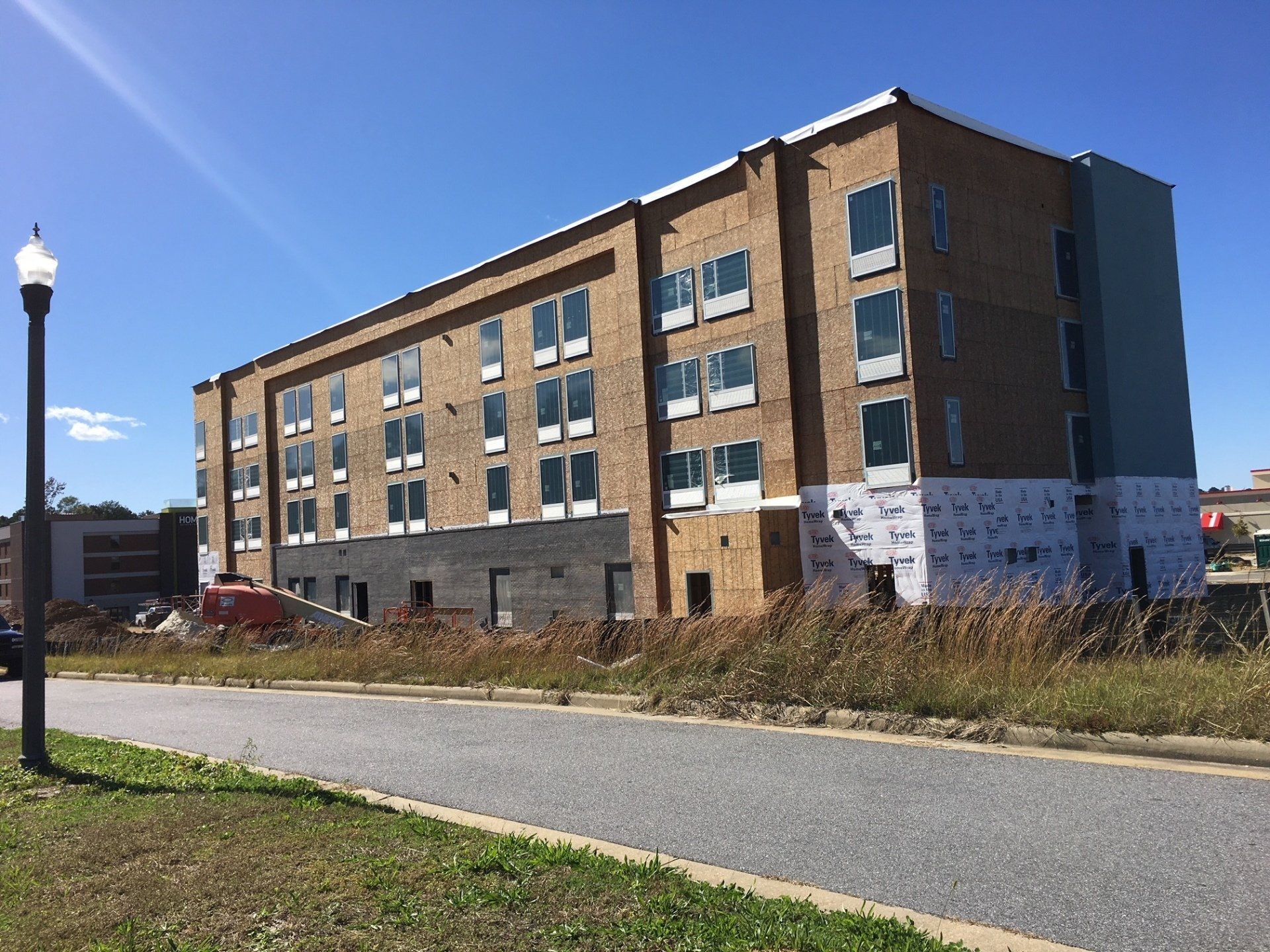 A large brick building with a lot of windows is under construction.