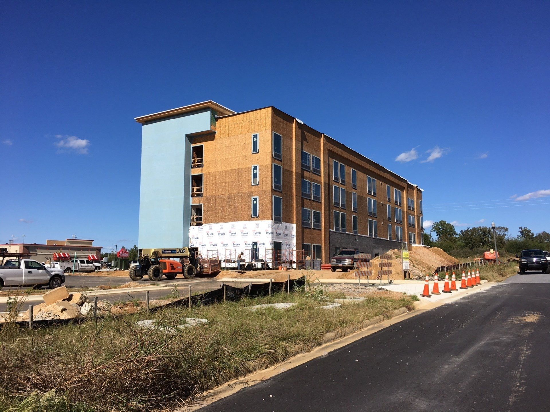 A large building is being built on the side of a road.