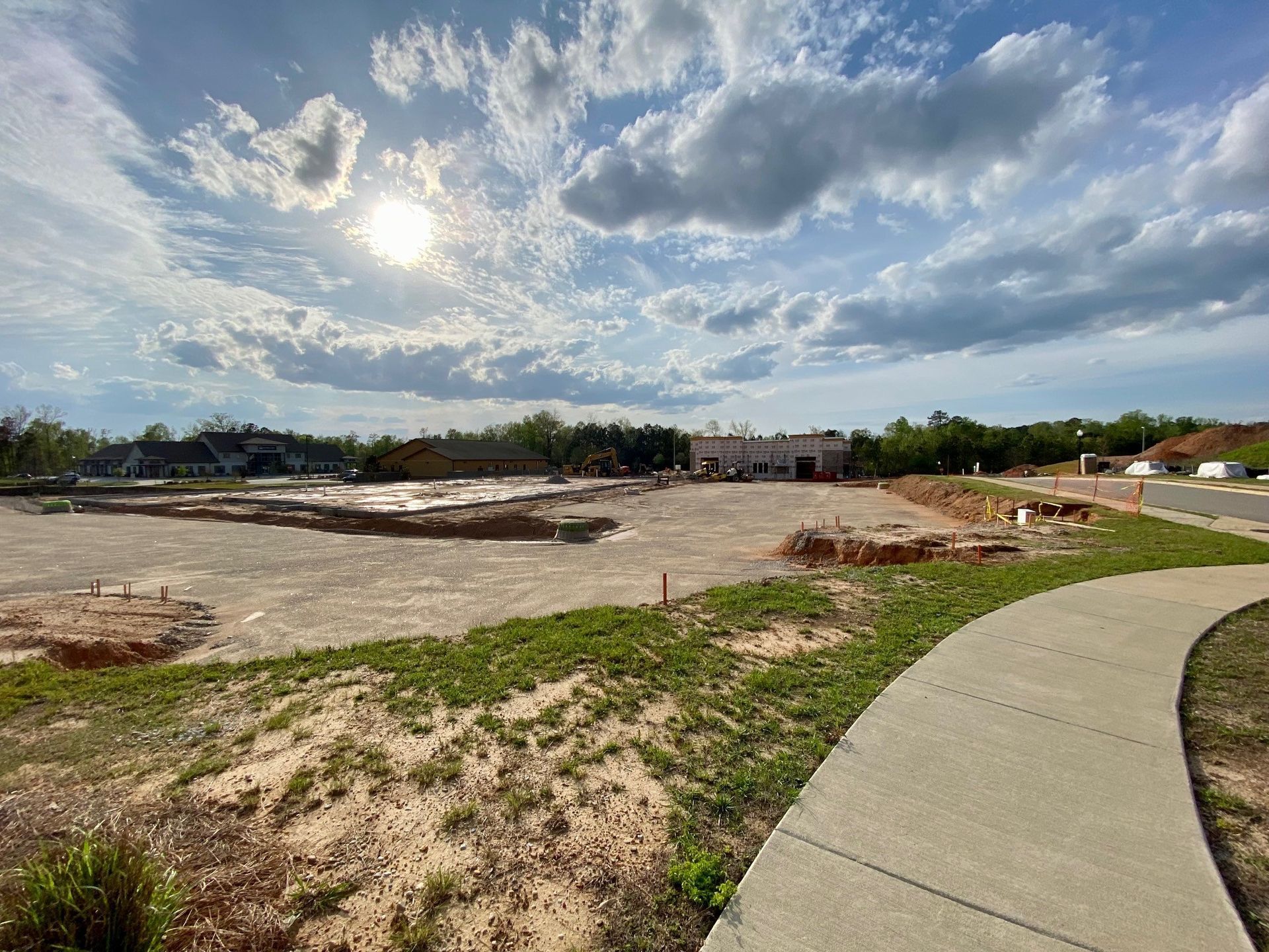 The sun is shining through the clouds over a construction site.