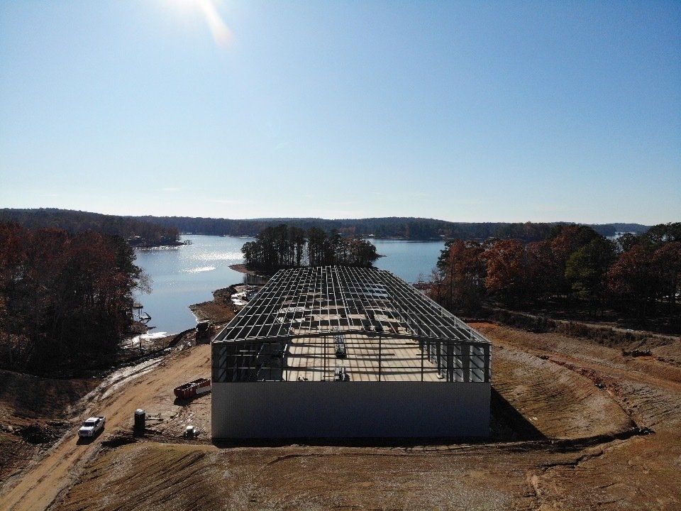 An aerial view of a building under construction next to a lake.