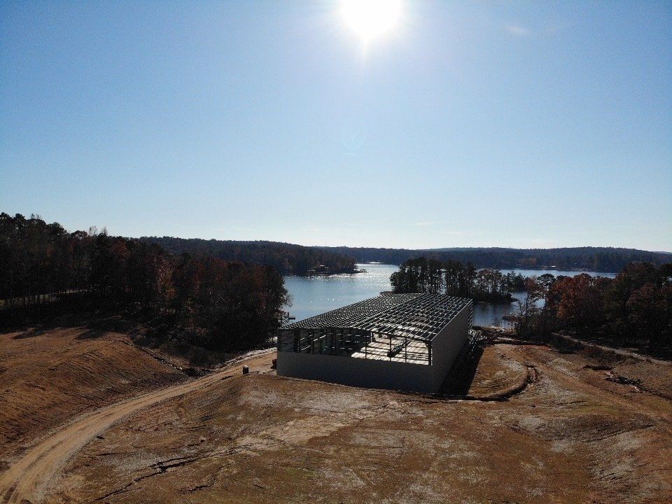 An aerial view of a building under construction next to a lake.