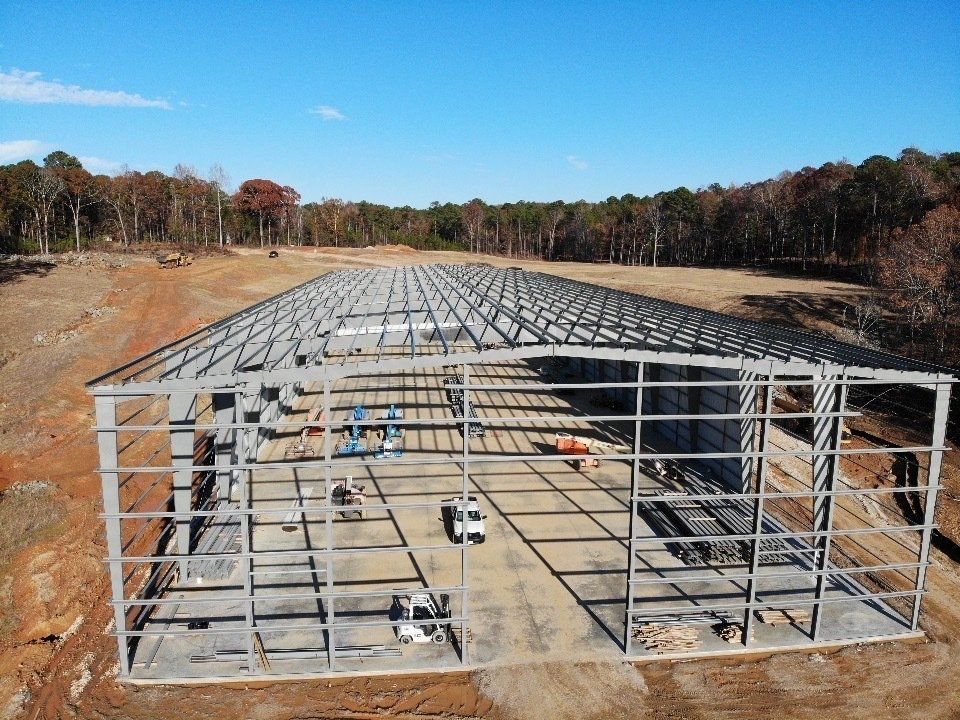 An aerial view of a large building under construction in a field.