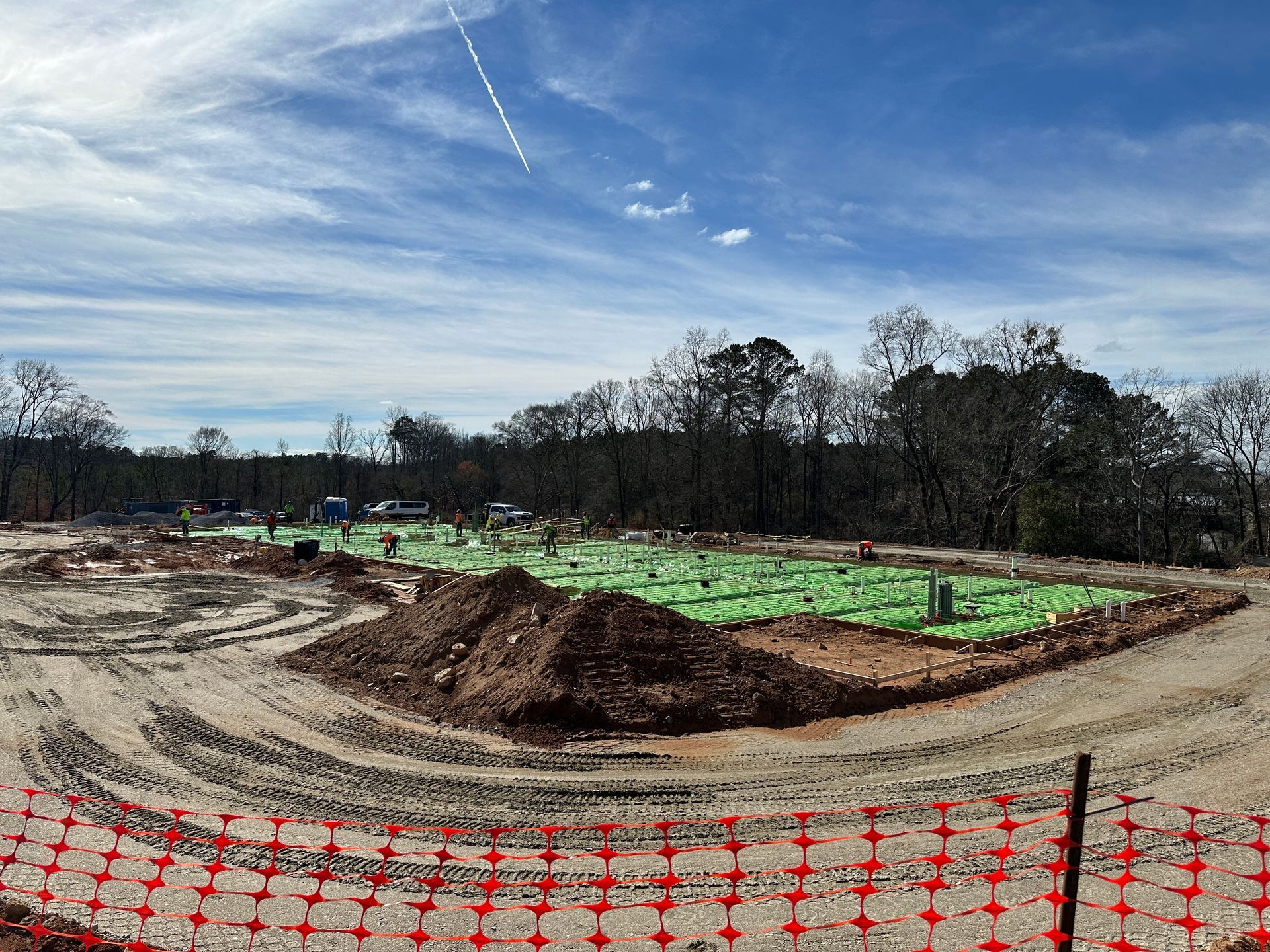 An aerial view of a new Hovey Precast office building with a blue roof surrounded by trees.