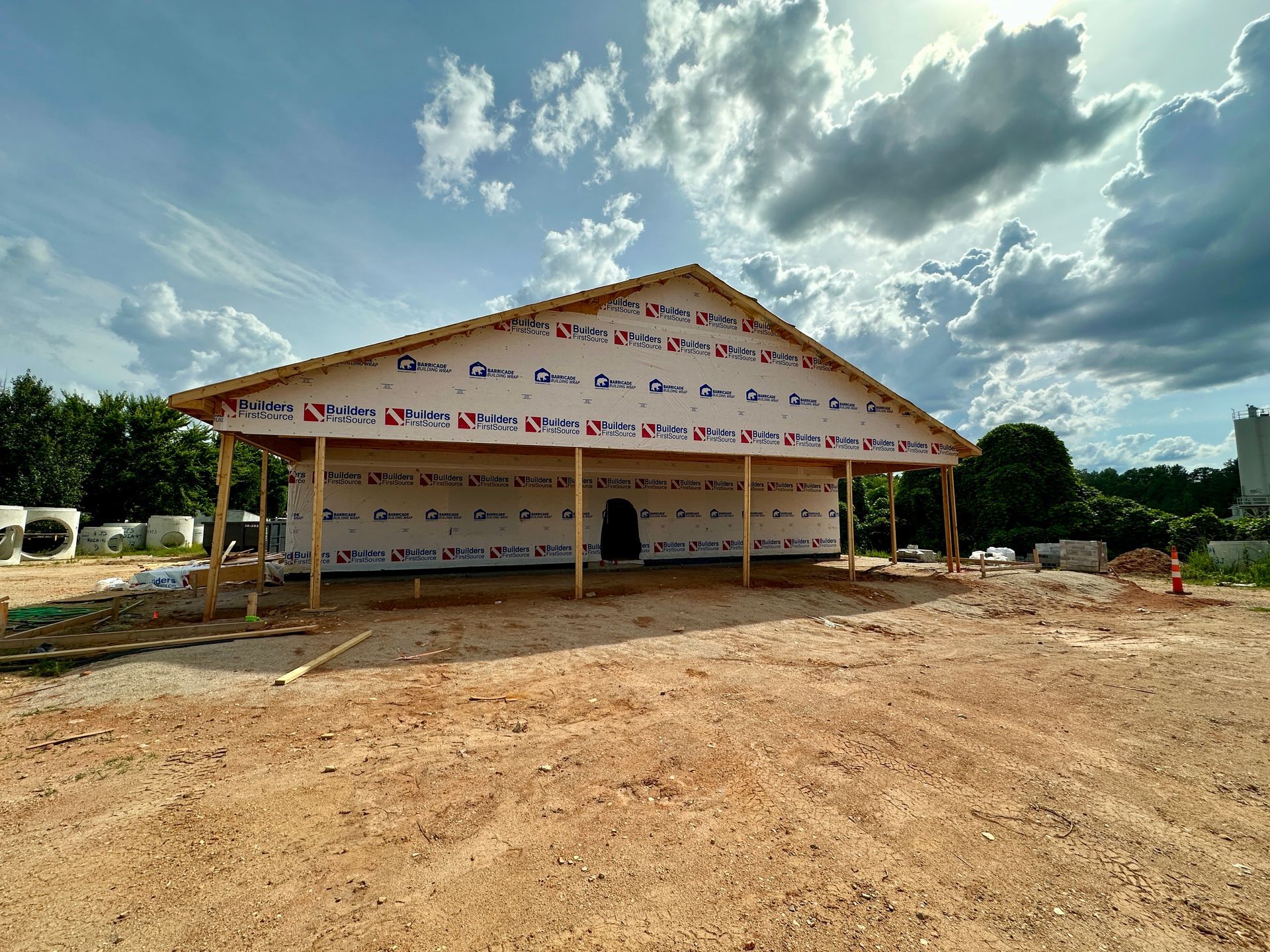 A large building is being built in a dirt field.