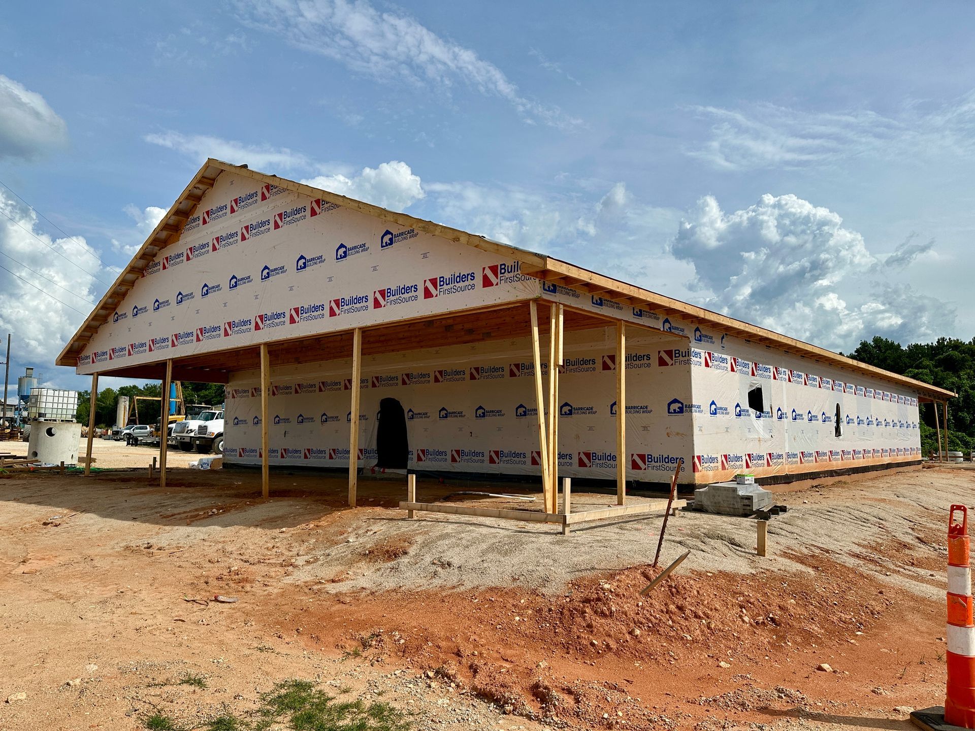 A large building is being built in the middle of a dirt field.