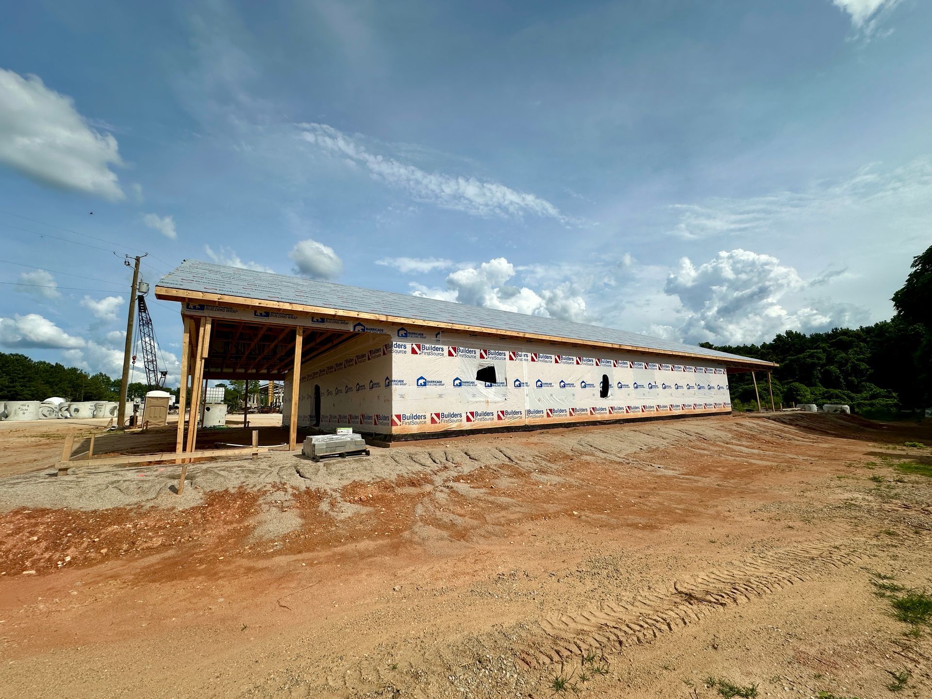 A large building is being built in a dirt field.