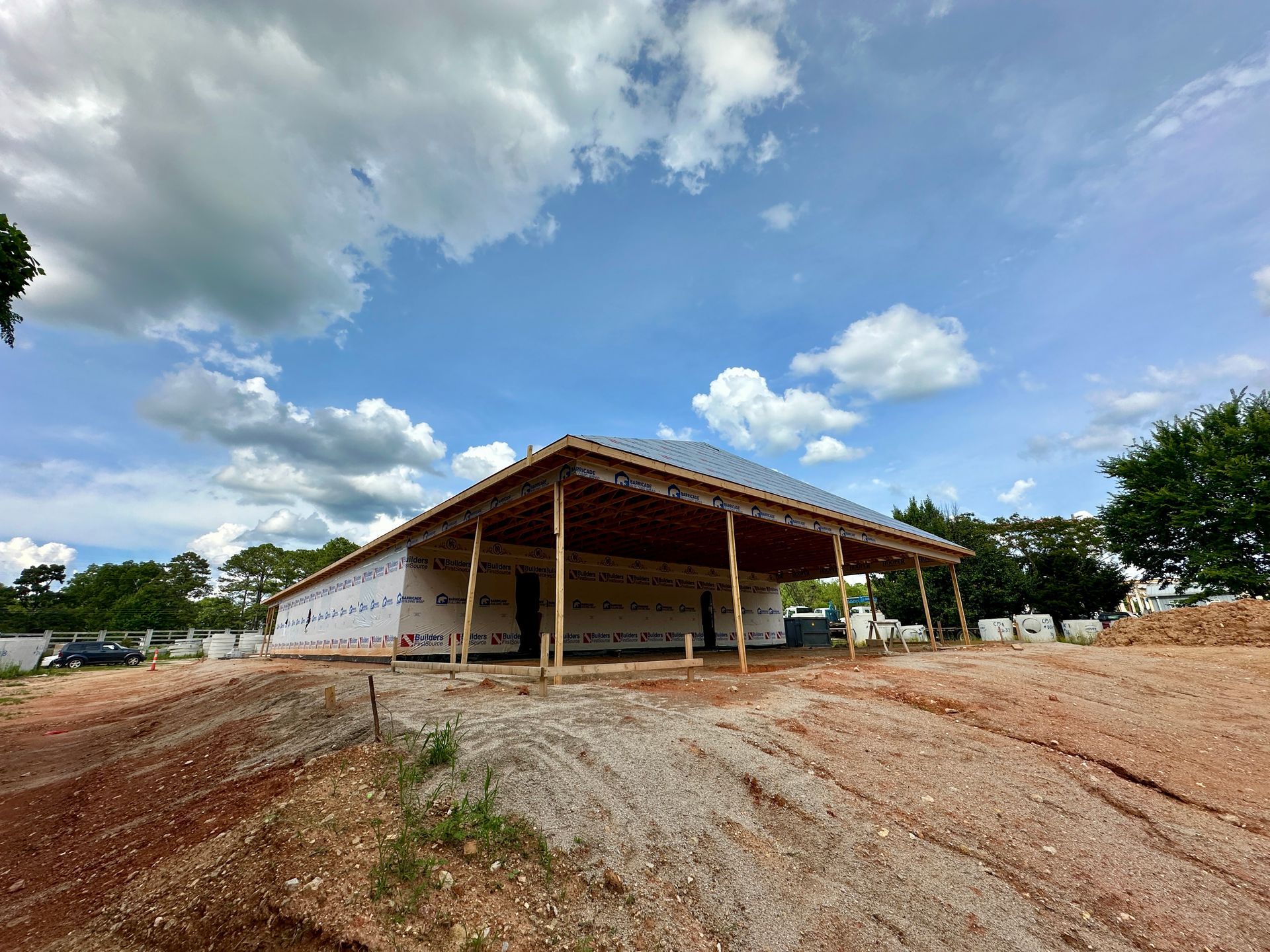 A large building is being built on top of a dirt field.