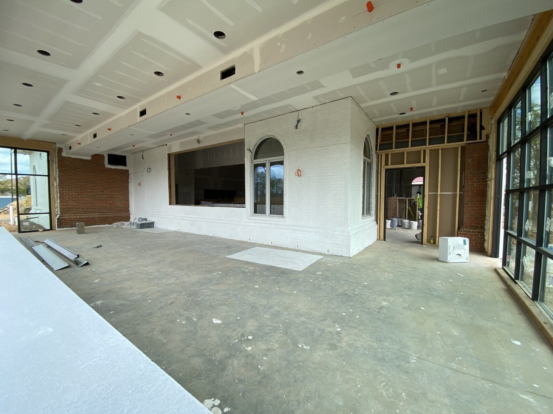 A large empty room with a lot of windows in a building under construction.