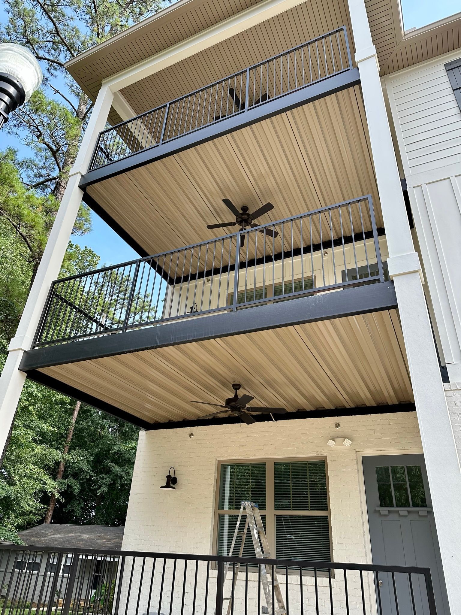 A house with three balconies and a ceiling fan.