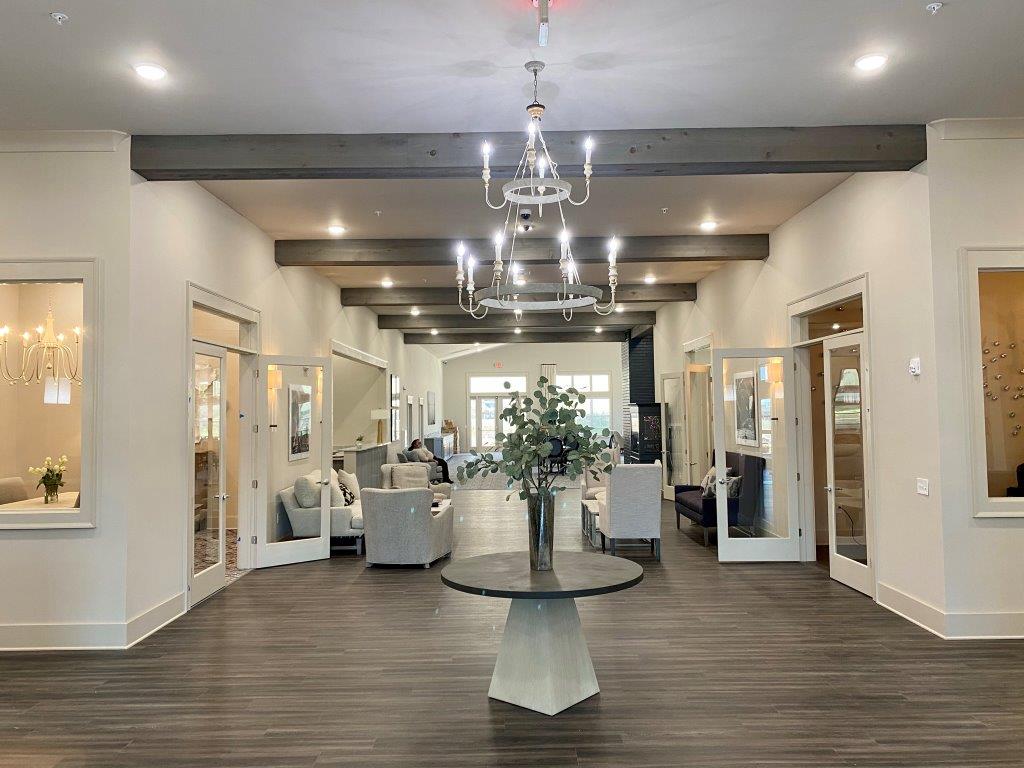 A large room with a table in the middle and a chandelier hanging from the ceiling.