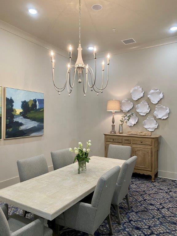 A dining room with a table and chairs and a chandelier.
