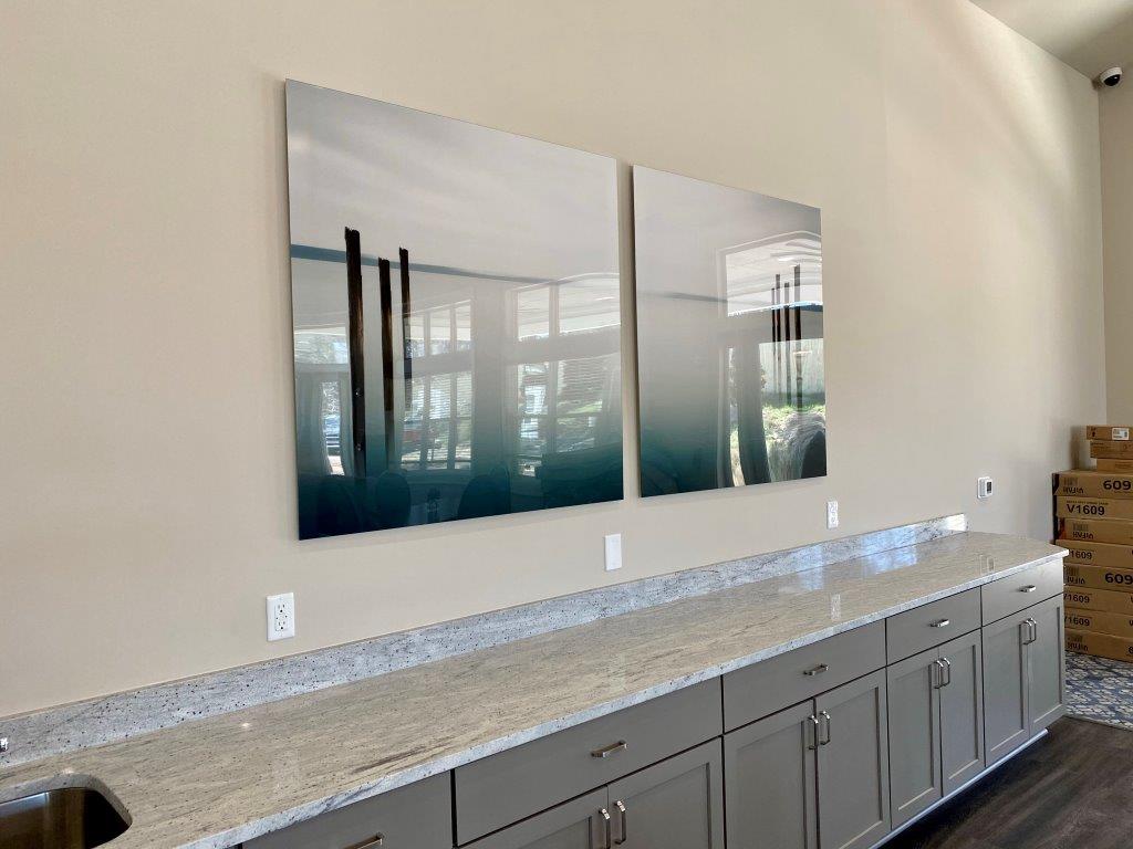 A kitchen with a sink and two paintings on the wall.