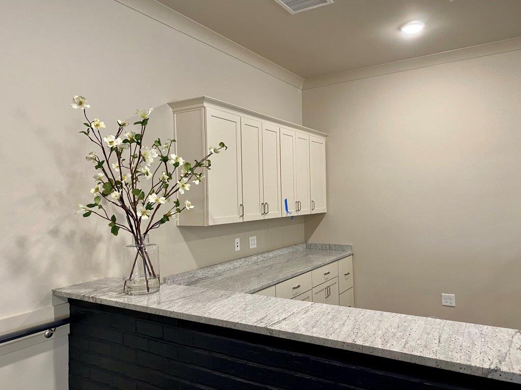 There is a vase of flowers on the counter in the kitchen.