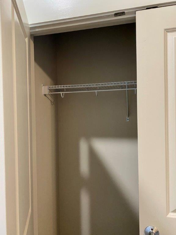 A closet with a door open and a shelf in it.