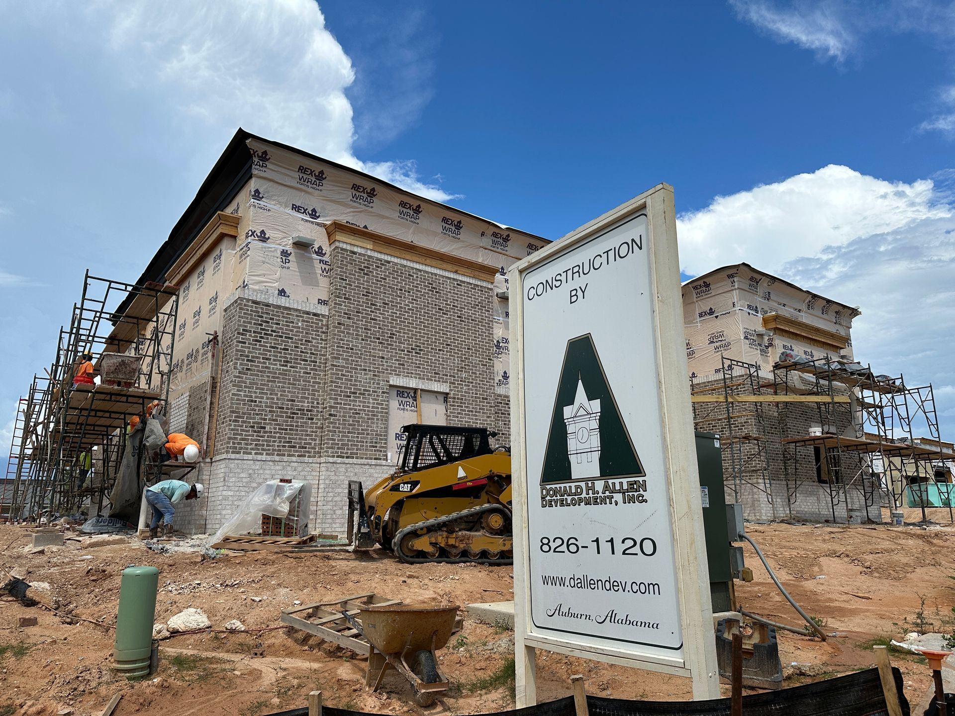 A large building under construction with a sign in front of it.