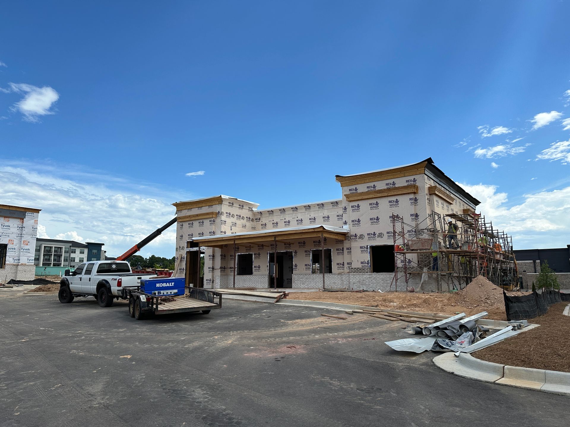 A truck is parked in front of a building under construction.
