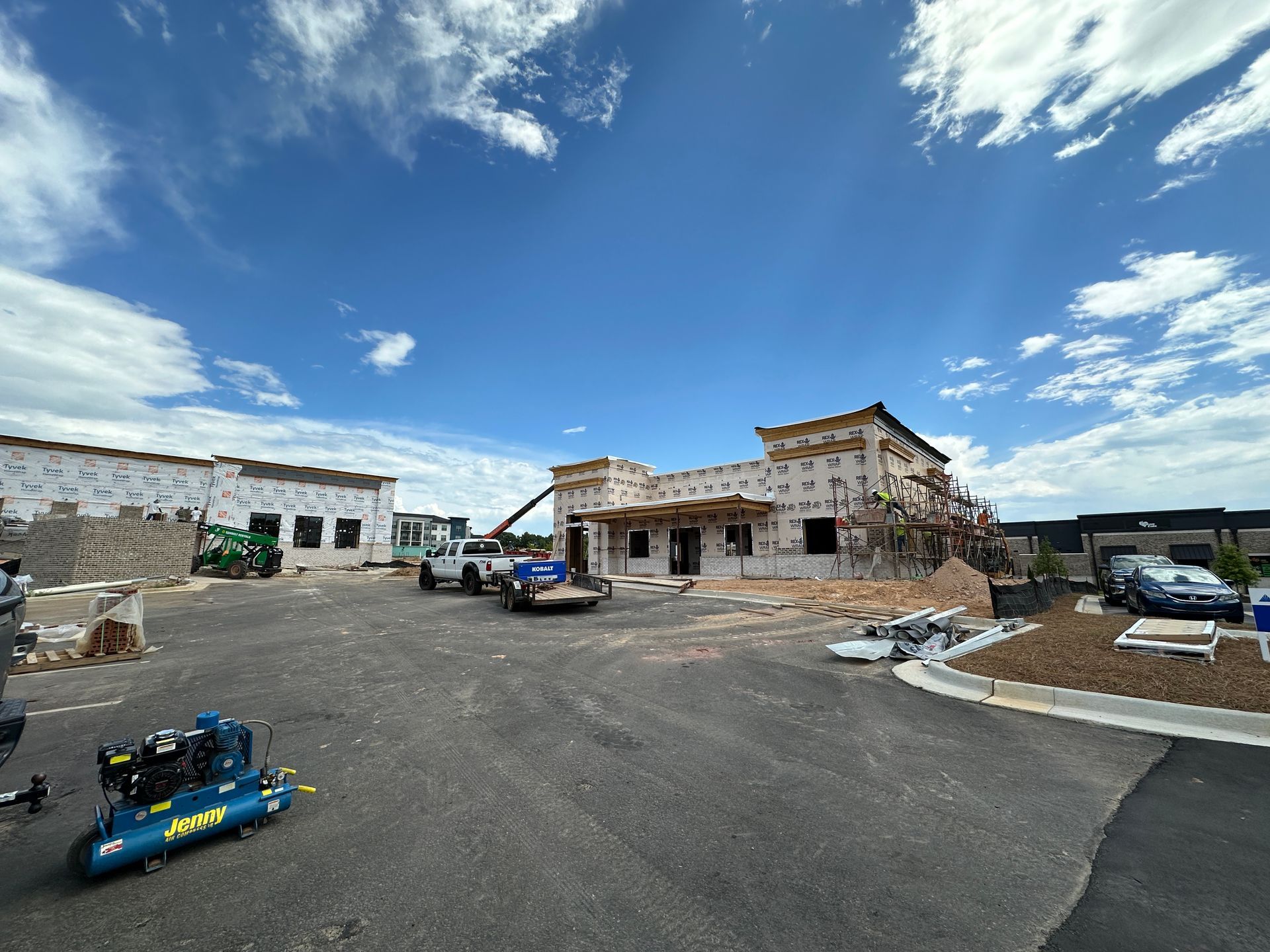 A large building is being built in a parking lot.