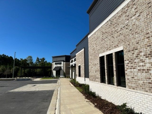 A brick building with a sidewalk leading to it