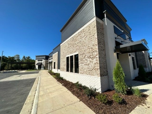A brick building with a sidewalk leading to it