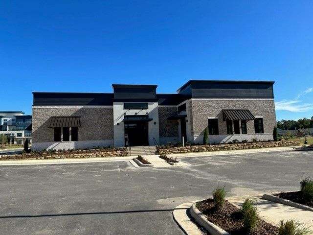 A large brick building with a parking lot in front of it.