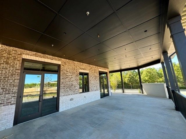 An empty room with a brick wall and a black ceiling.