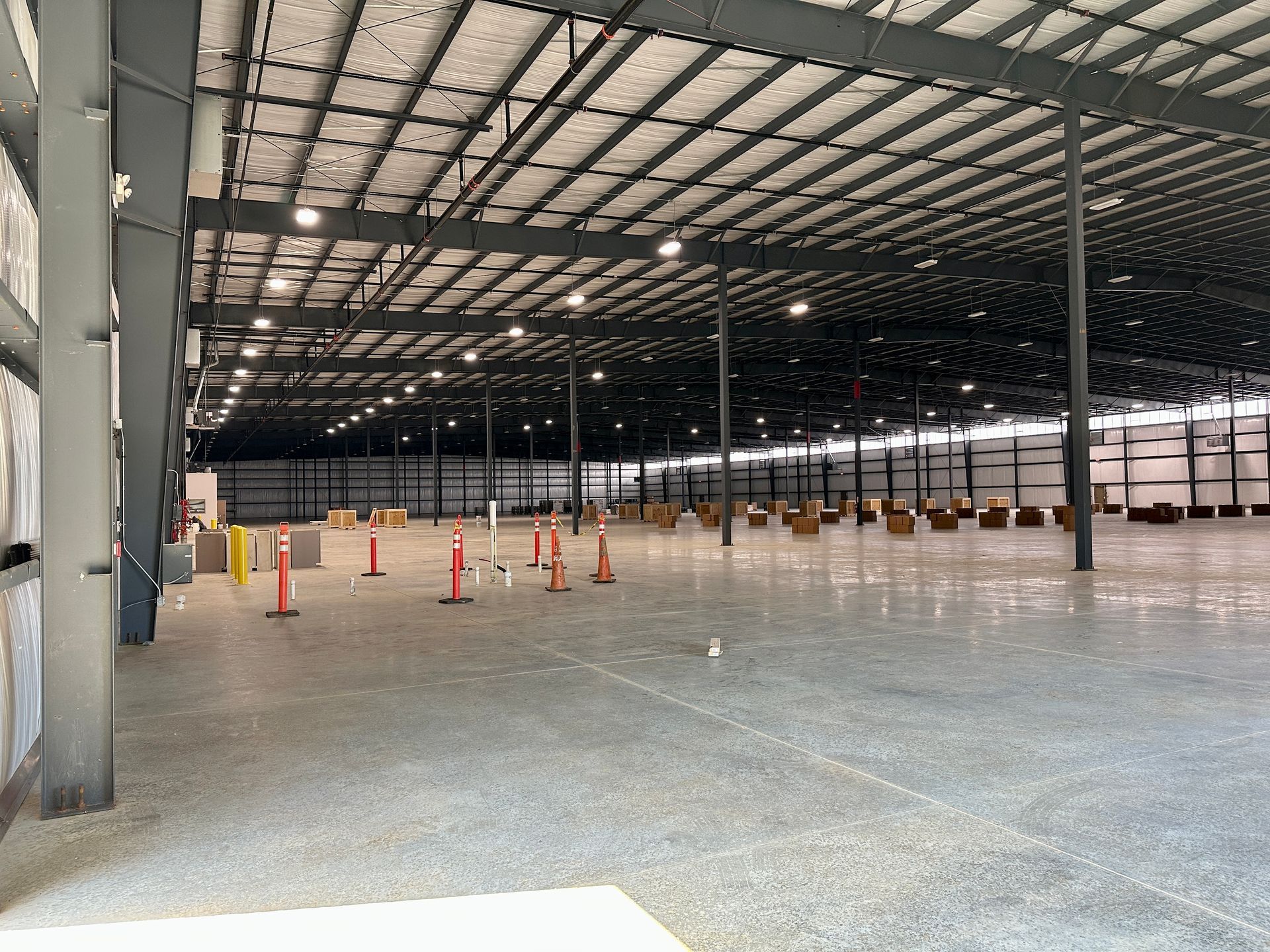 A large empty warehouse with a lot of boxes on the floor.
