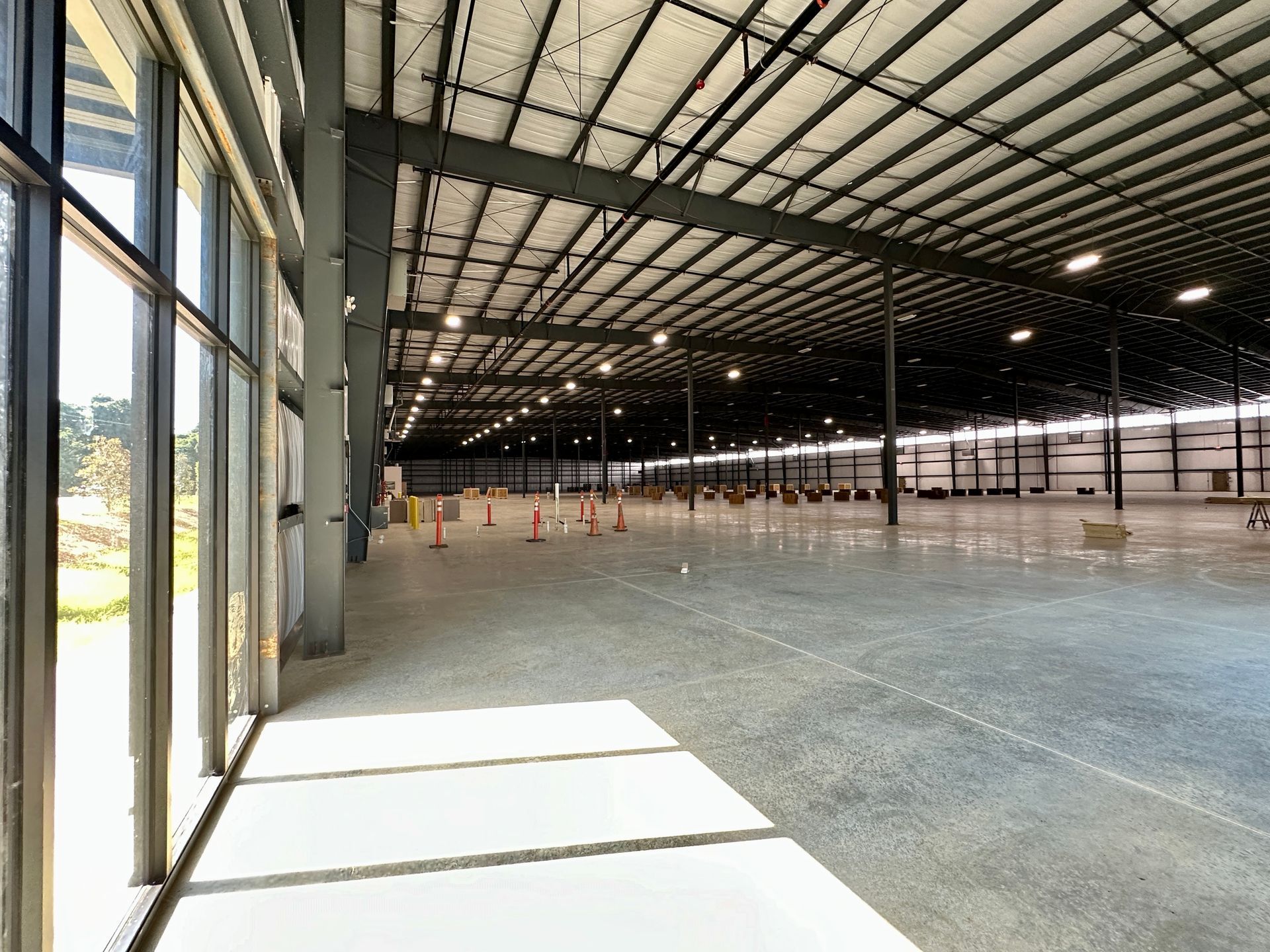 A large empty warehouse with lots of windows and concrete floors.