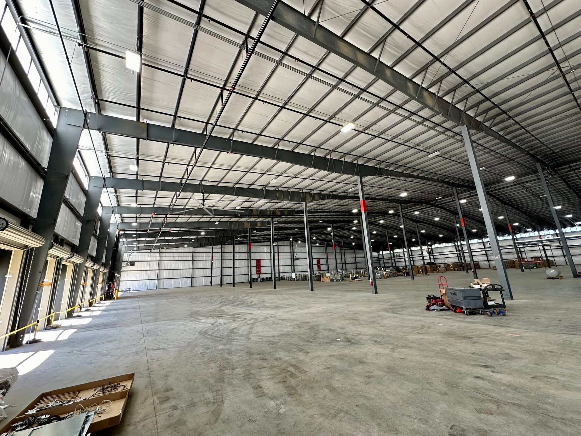 A large empty warehouse with a lot of windows and a ceiling.