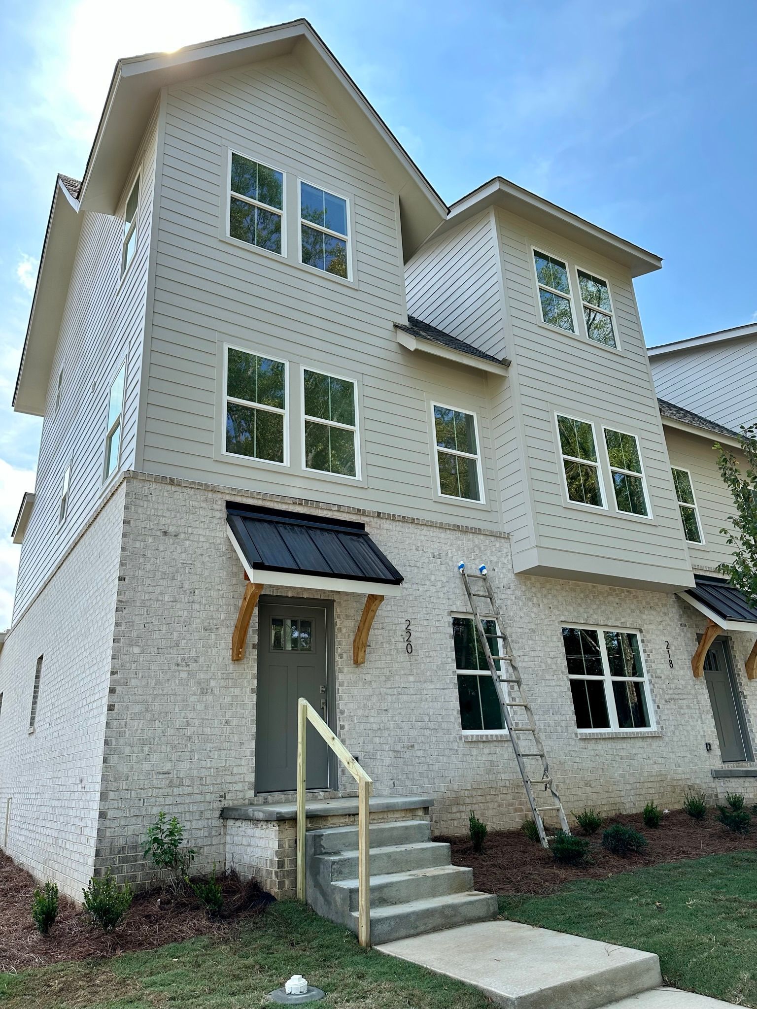 A large white house with a ladder in front of it.