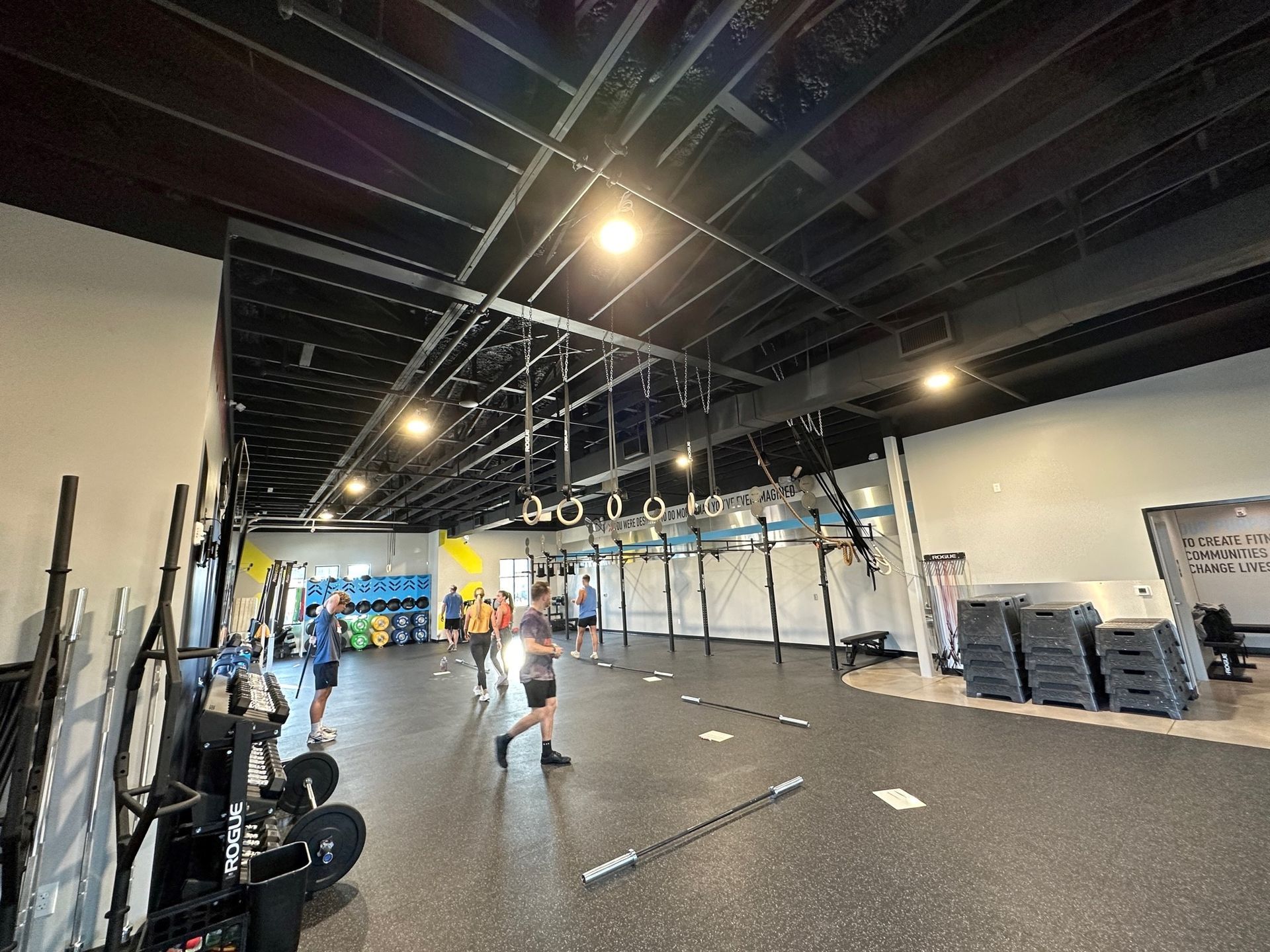 A group of people are standing in a large gym.