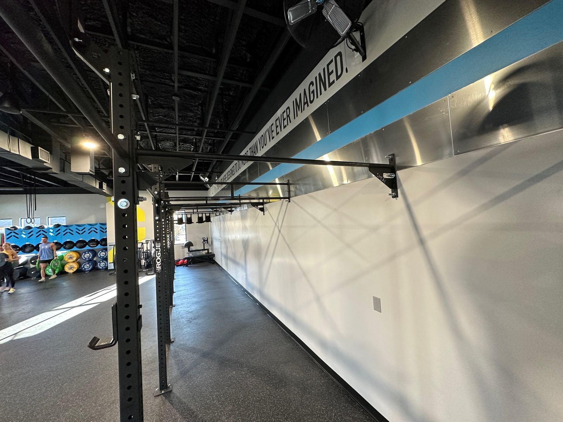A long hallway in a gym with a sign on the wall that says ' i am humbled '
