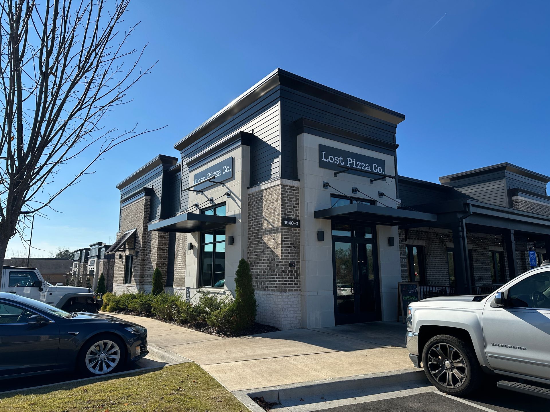 A large building under construction with a red dumpster in front of it.