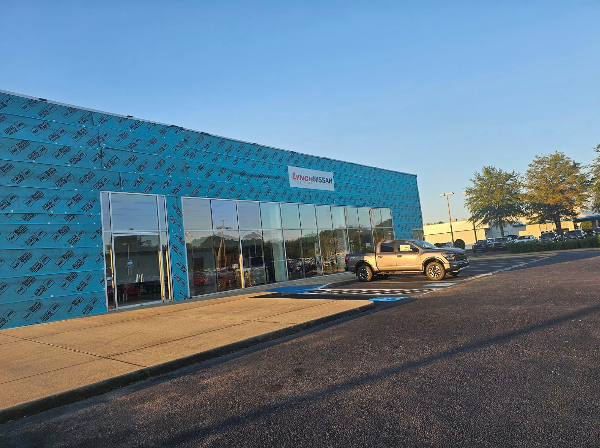 A blue building with a white truck parked in front of it.