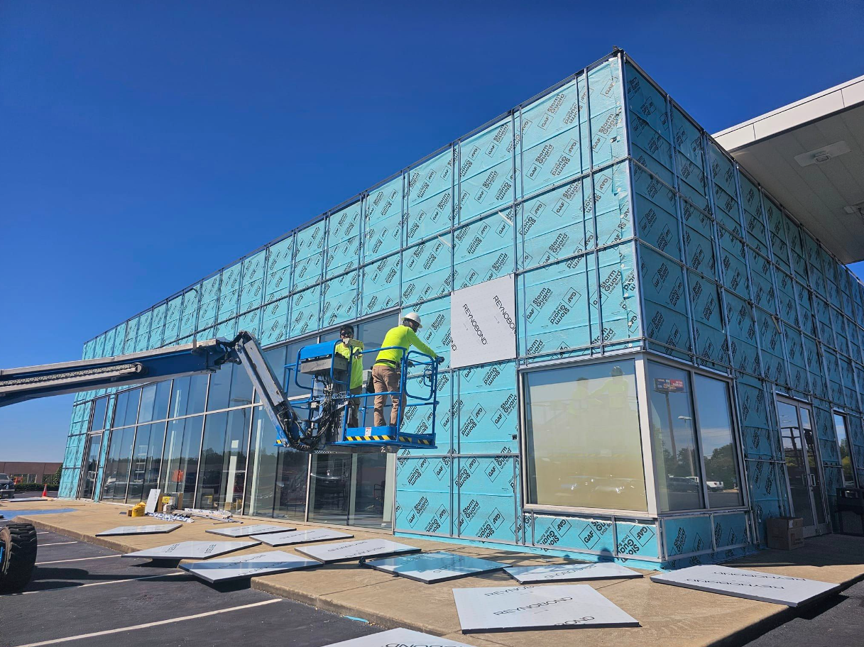 Two men are working on the side of a building.