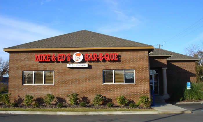 A brick building with a red sign that says mike and ed 's barbecue
