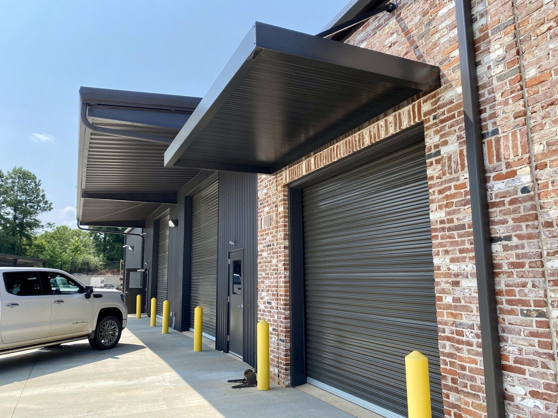 A white truck is parked in front of a brick building.