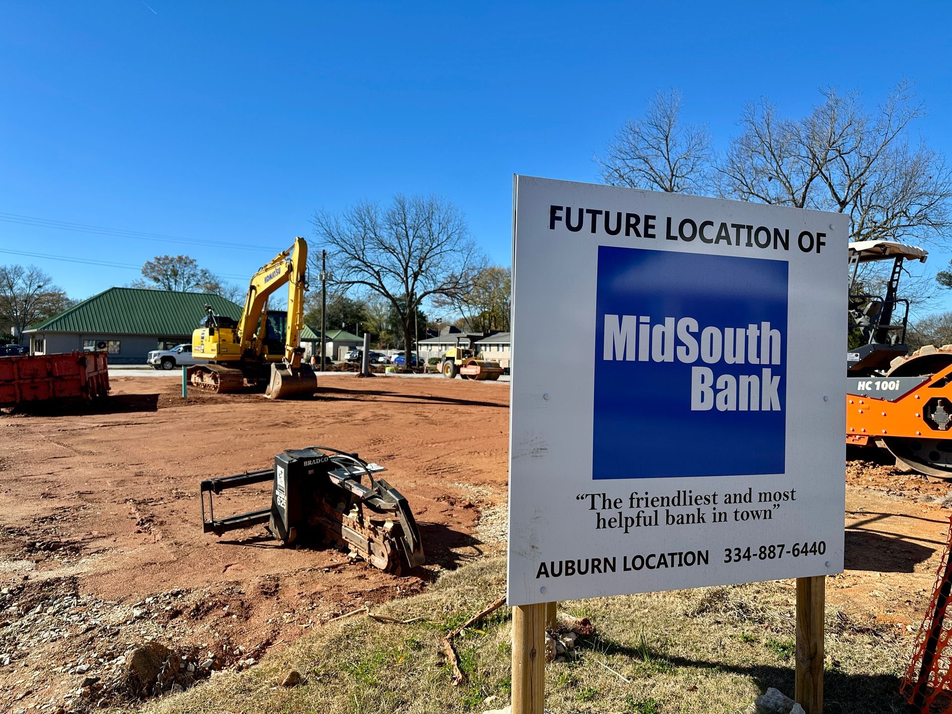 An aerial view of a new Hovey Precast office building with a blue roof surrounded by trees.